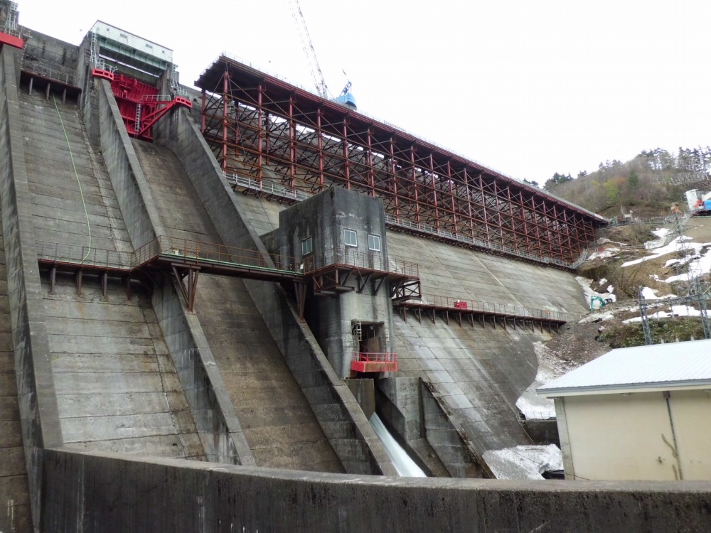笠堀ダムの2015年4月14日時点の施工状況。下流側堤体上部に仮設構台を設置して、かさ上げ・増し打ちコンクリートの準備を進めているところ