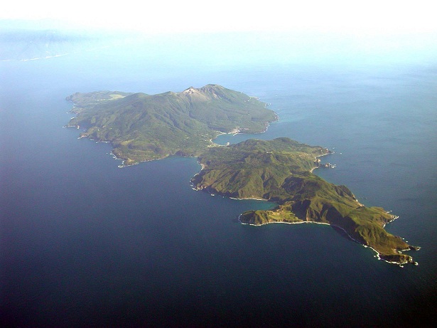 口永良部島 （ くちのえらぶじま ）爆発的噴火前の様子　口永良部島全景を北西から見る　火口に向かって右の島の西側海岸には変色水が見られる　2003年10月20日　海上保安庁 撮影