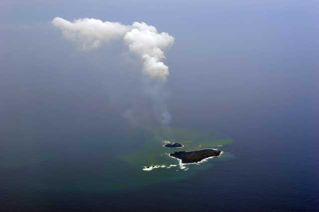 西之島（西ノ島）と西之島 新島の付近 2013年12月1日14:35 海上保安庁撮影　溶岩流の流出により新島は拡大している