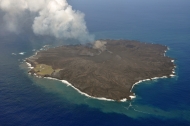 西之島（西ノ島） 全景 2014年9月17日14:31 海上保安庁撮影　旧西之島はほぼ溶岩流に覆われた　左下海岸線付近の色の薄い部分が旧西之島