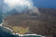 西之島（西ノ島） 西之島を覆う溶岩流 2014年9月17日14:34 海上保安庁撮影　左下海岸線付近の色の薄い部分が旧西之島