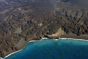 旧西之島（旧西ノ島）の一部 2014年12月25日11:21 海上保安庁撮影　旧西之島（色の薄い部分）は高台部分を除いて、ほぼ新島に飲み込まれた