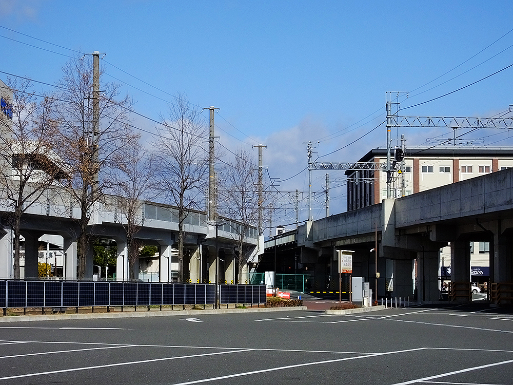 梅小路公園・京都鉄道博物館前バス停付近から、複線の山陰線「七条高架橋」（右）と単線の東海道線支線「梅小路高架橋」（左）の軌道を見る。写真左奥に市中央卸売市場第一市場水産事務所棟が見える