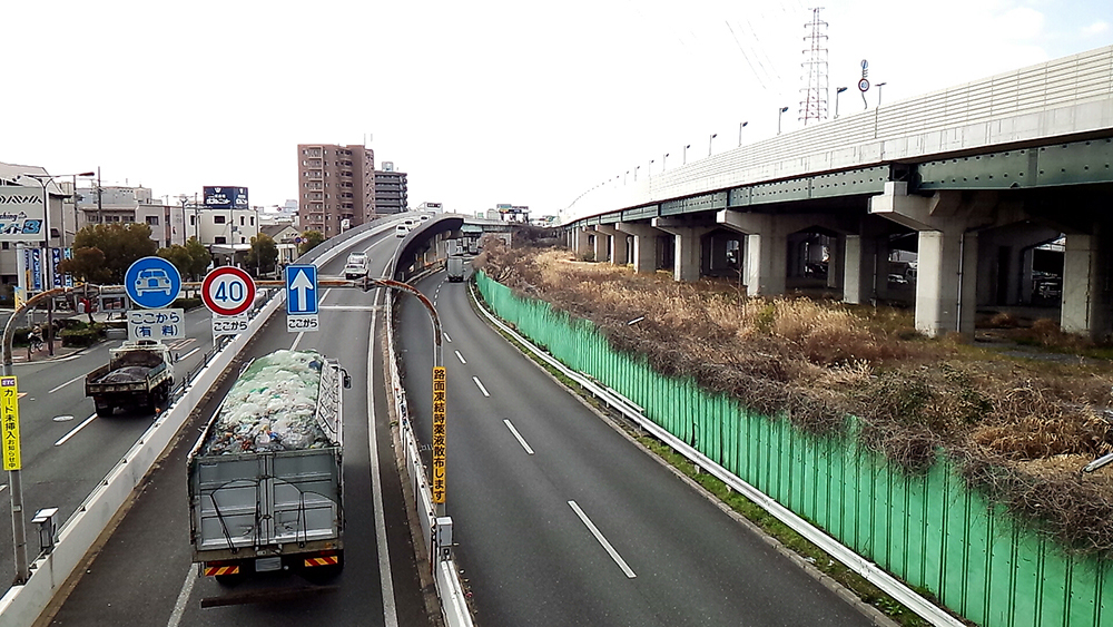 大阪市鶴見区茨田大宮の歩道橋から中環外回りを見る。中環と近畿自動車道の間に空きスペースが見え
